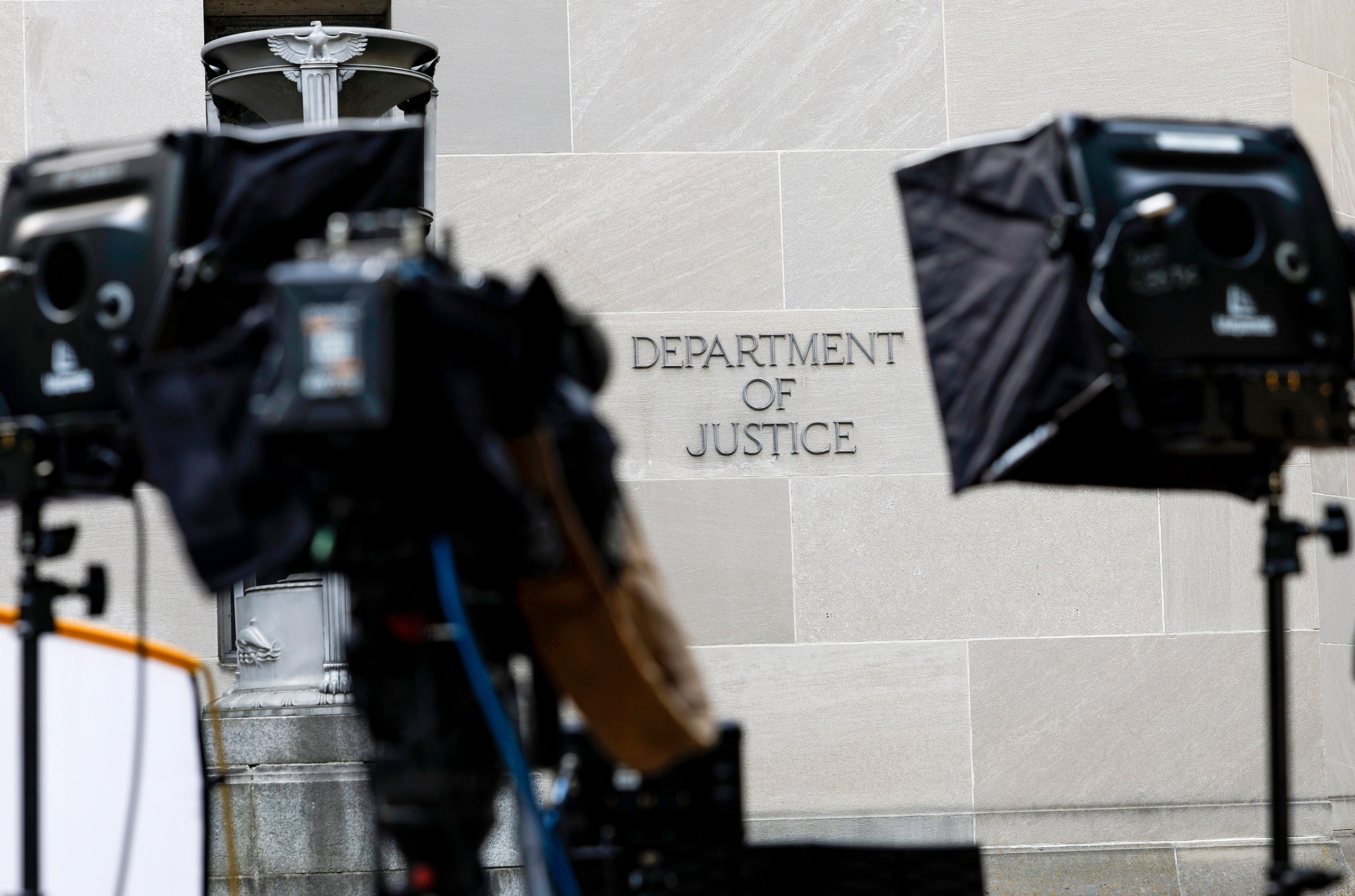 Camera equipment is set up in front of the U.S. Department of Justice.
